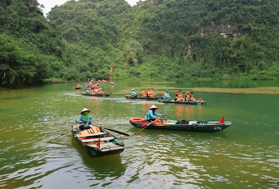 Best Time to Visit Ninh Binh: boatman rowing on Ngo Dong River in Tam Coc