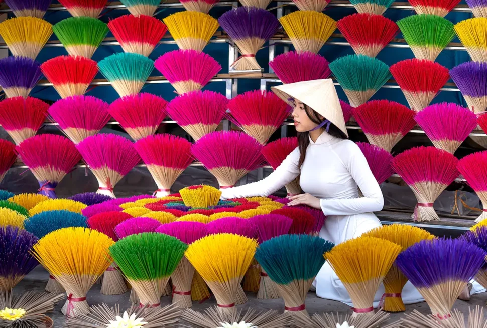 Woman among colorful incense sticks at Quang Phu Cau Village