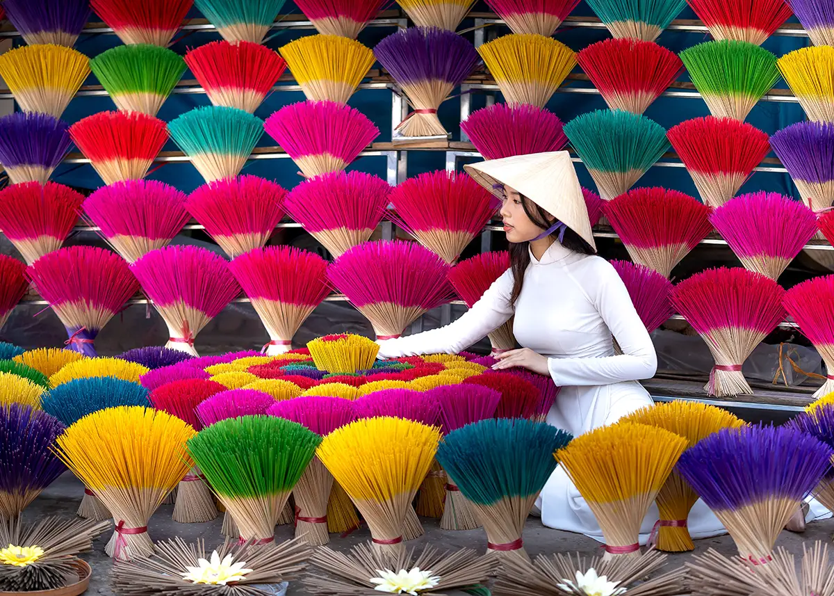 Woman among colorful incense sticks at Quang Phu Cau Village