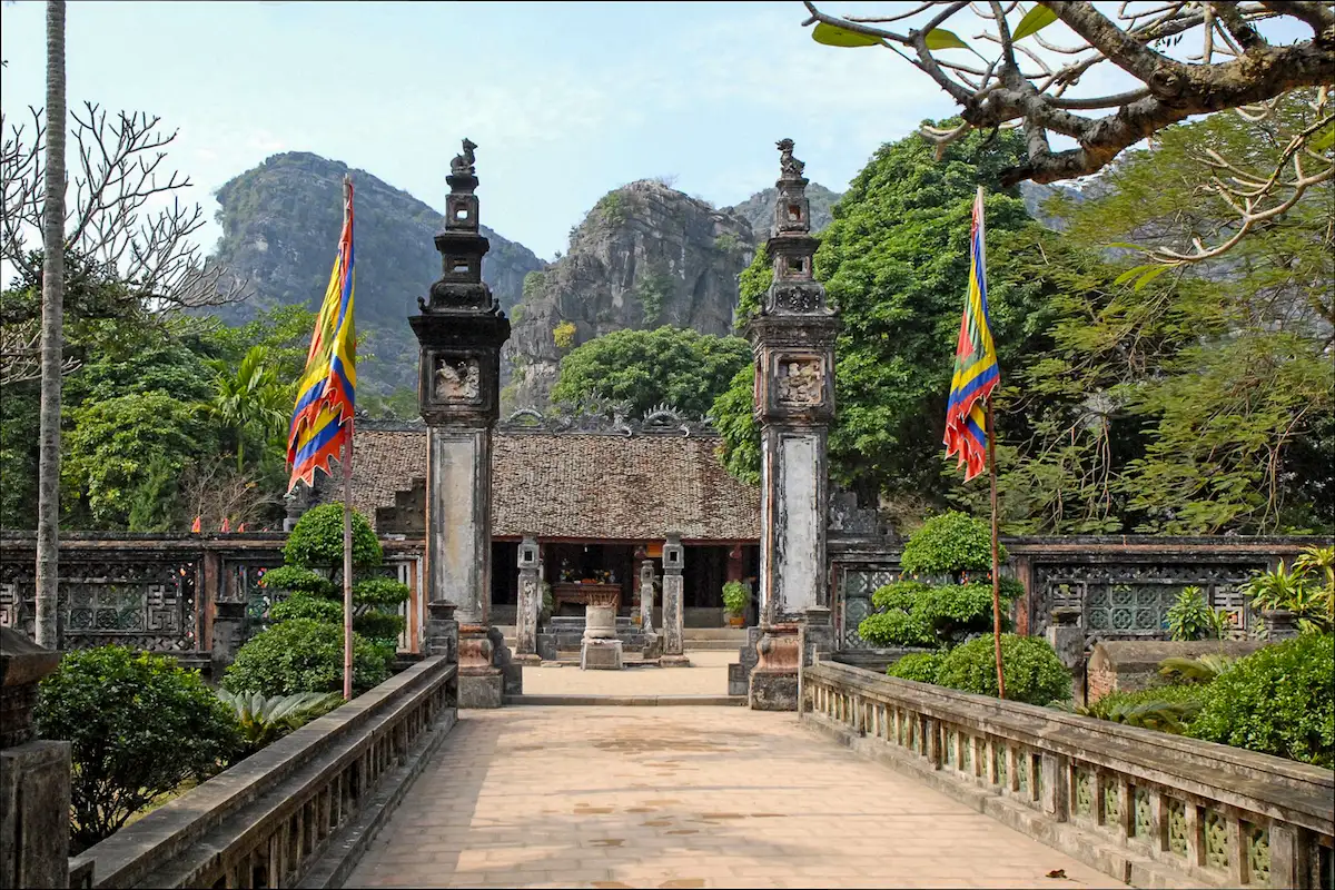 Ancient entrance gate of King Dinh Temple surrounded by limestone mountains in Ninh Binh