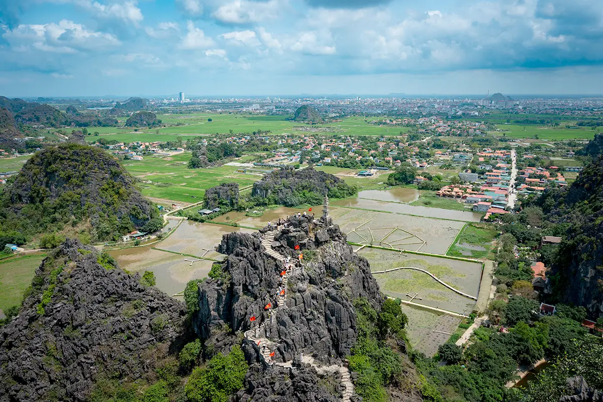 Panoramic view of limestone mountains, rice fields, and Ninh Binh from Mua Cave