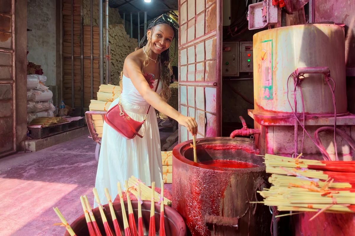 Woman demonstrating the traditional incense dyeing process in Quang Phu Cau