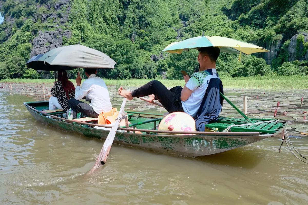 Tam Coc boat tour with travelers on the Ngo Dong River in Ninh Binh