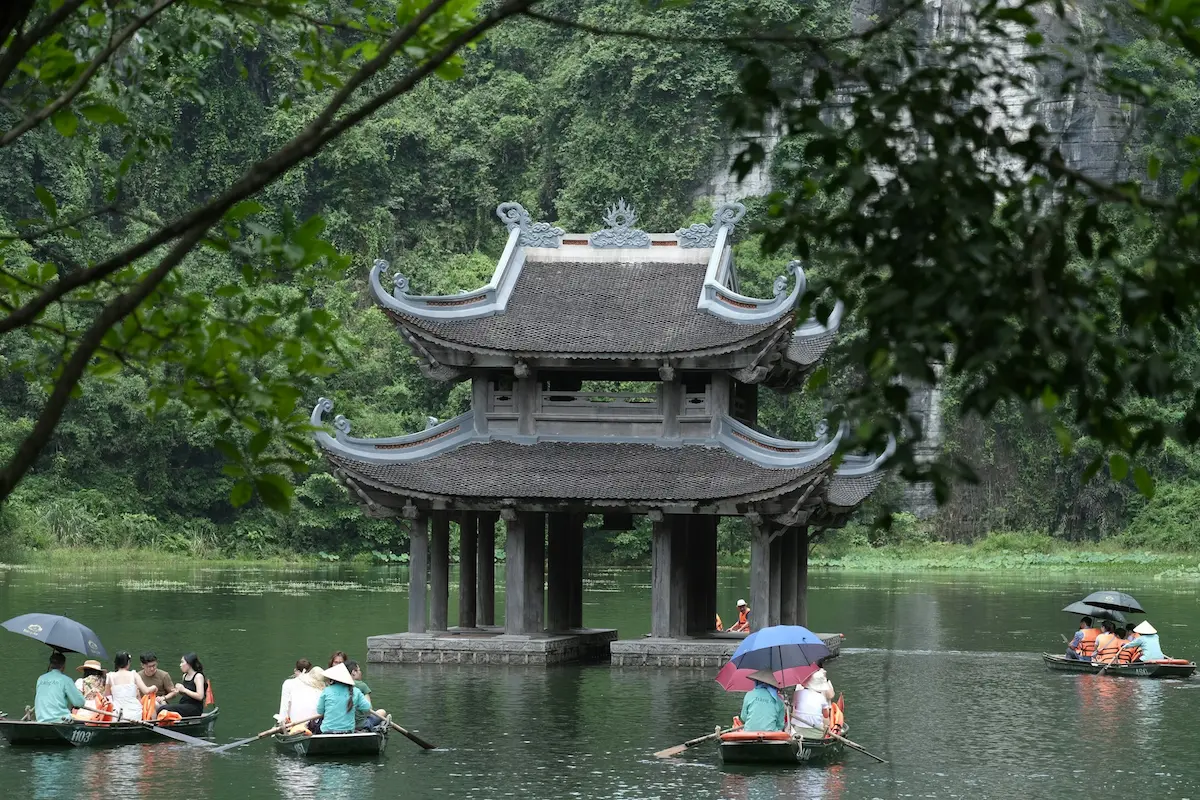 Traditional pavilion surrounded by limestone cliffs in Trang An, Ninh Binh, Vietnam