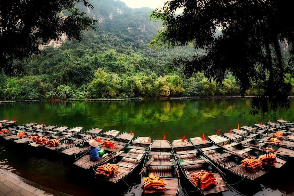 Wooden boats in Trang An waiting for tourists to explore Ninh Binh waterways.