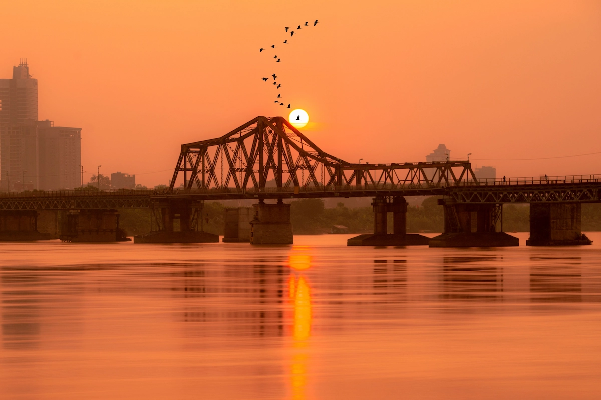 Scenic sunset view over the historic Long Bien Bridge spanning the Red River on a Hanoi culture tour