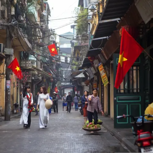 Traditional streets and Vietnamese flags during a Hanoi walking tour