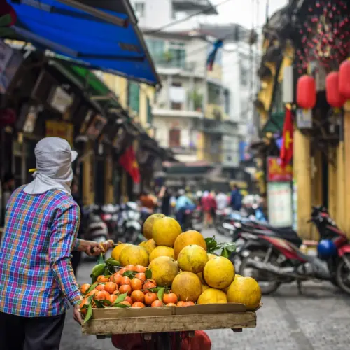 Local fruit vendor with fresh produce on a Hanoi walking tour