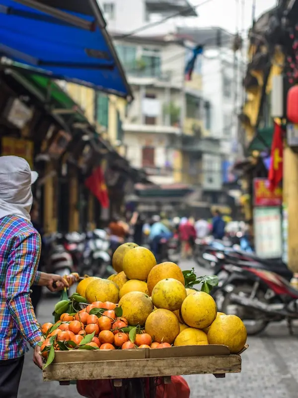 Local fruit vendor with fresh produce on a Hanoi walking tour