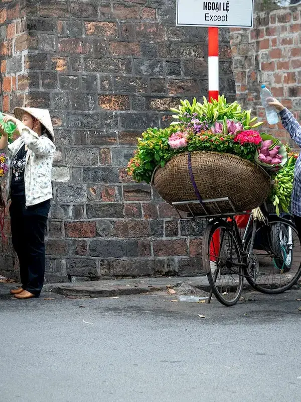 Flower vendors with bicycles along Hanoi's historic Old Quarter streets