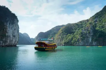 Cat Ba Island Travel Guide: Tourist boat cruising through limestone karsts in Cat Ba Island