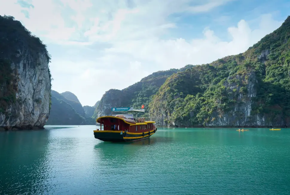 Cat Ba Island Travel Guide: Tourist boat cruising through limestone karsts in Cat Ba Island