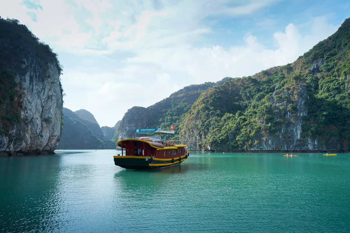 Cat Ba Island Travel Guide: Tourist boat cruising through limestone karsts in Cat Ba Island