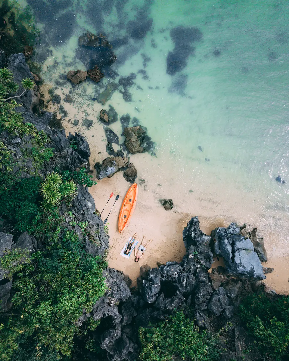 Travelers relaxing on a sandy beach in Lan Ha Bay