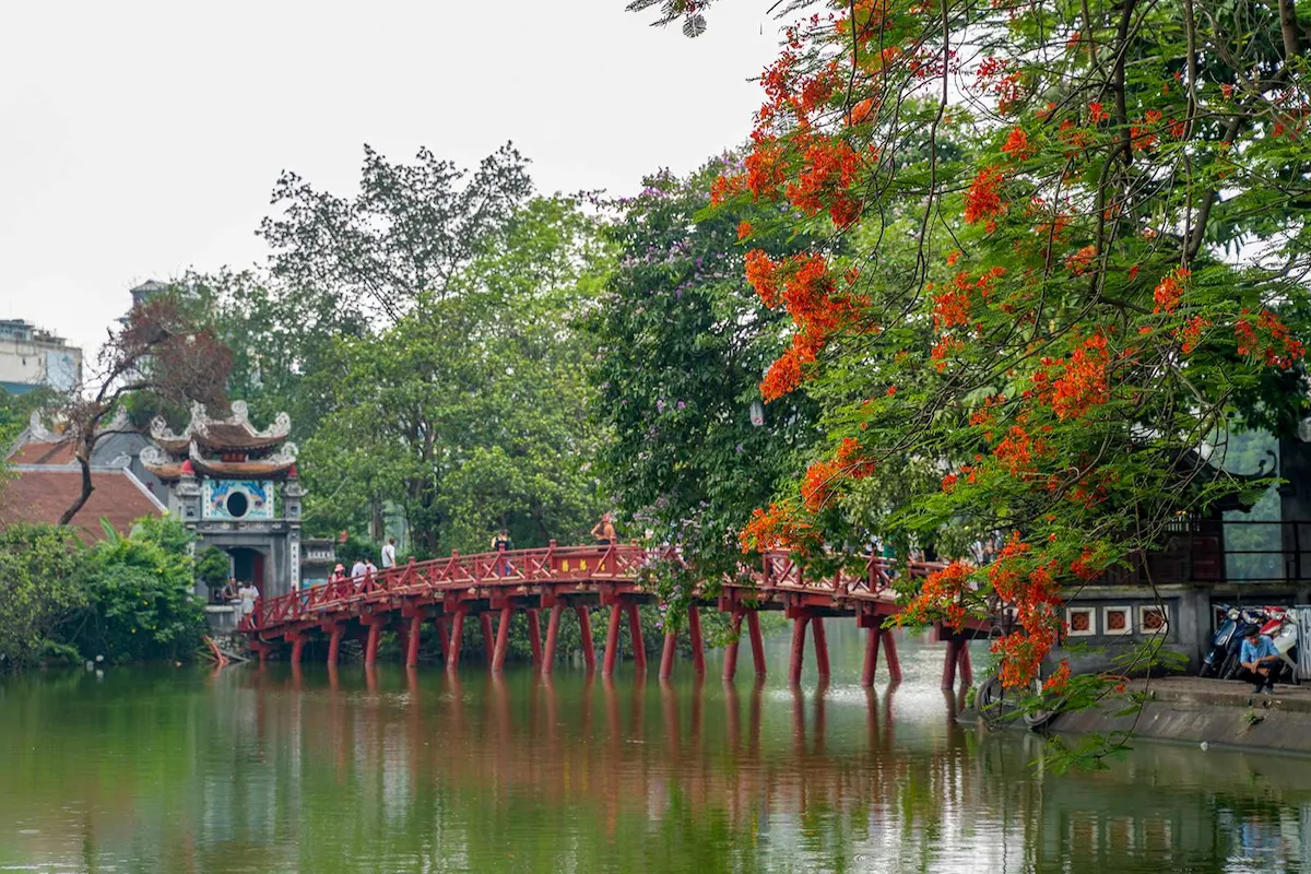 The red The Huc Bridge leading to Ngoc Son Temple at Hoan Kiem Lake in Hanoi