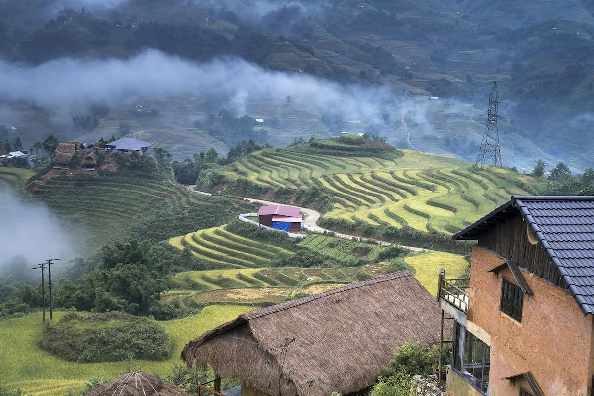 Misty morning view over traditional houses and terraced fields in Sapa