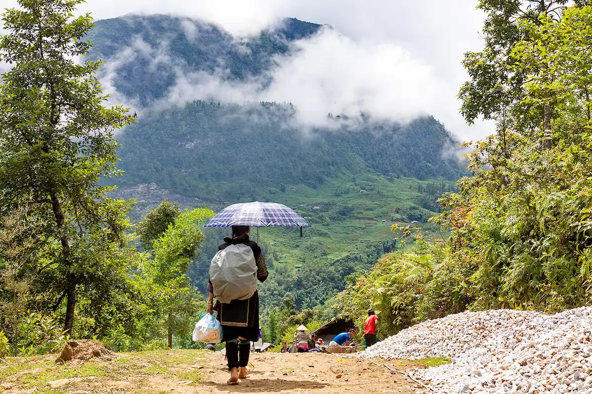 Local Hmong woman walking along a scenic Sapa trekking route